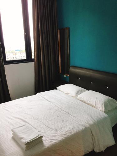 a bedroom with a bed with white sheets and a window at Perfect Getaway @Vivacity in Kuching