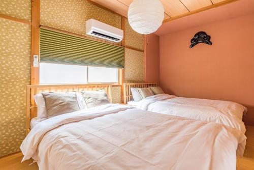 a bedroom with two beds and a window at Tino Kawara in Osaka
