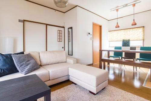 a living room with a white couch and a table at Tino Kawara in Osaka