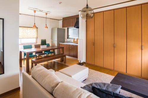 een woonkamer en keuken met een bank en een tafel bij Tino Kawara in Osaka