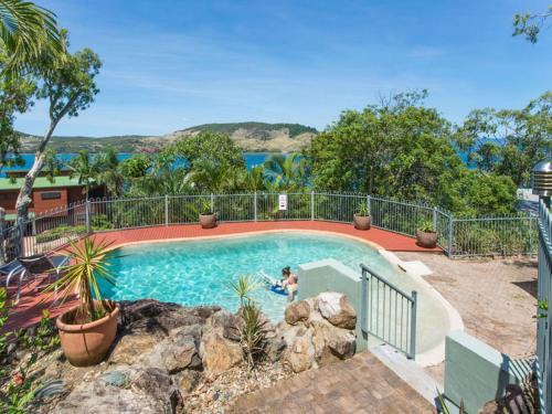 a person standing in a swimming pool in a house at Heliconia Grove - 1 bedroom - on Hamilton Island by HIHA in Hamilton Island
