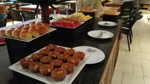 een toonbank met meerdere schalen chocolademuffins en desserts bij Supalai Scenic Bay Resort And Spa, SHA Extra Plus in Por Bay