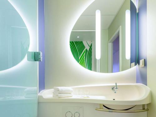 een badkamer met een wastafel en een spiegel bij ibis budget Krefeld Messe-Düsseldorf in Krefeld