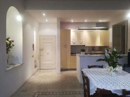 a kitchen and dining room with a table and a white door at Residenza d'Epoca " Il Campo" by FrancigenaApartments in Siena