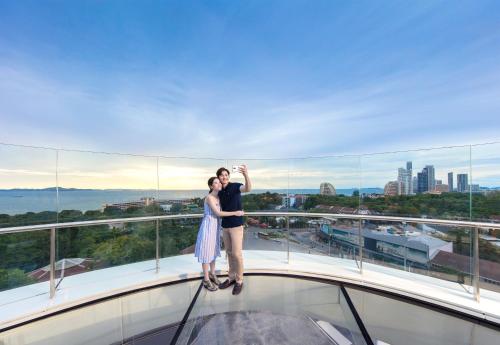 a couple standing on the glass floor of a building at Grande Centre Point Pattaya in Pattaya Central