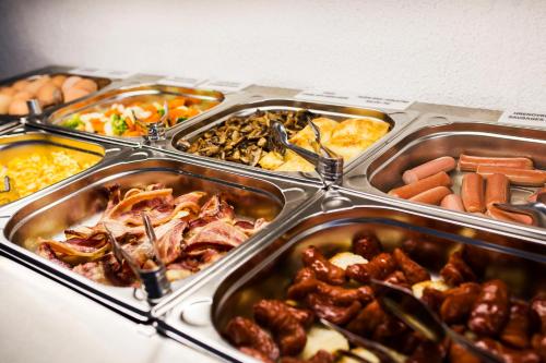 a buffet of different types of food in trays at Garden Hotel in Zagreb