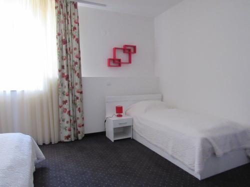Guest House Klaudija في تروغير: غرفة نوم مع سرير وعبار احمر على الحائط