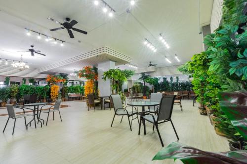 a dining room with tables and chairs and plants at Three Seasons Place in Bangkok