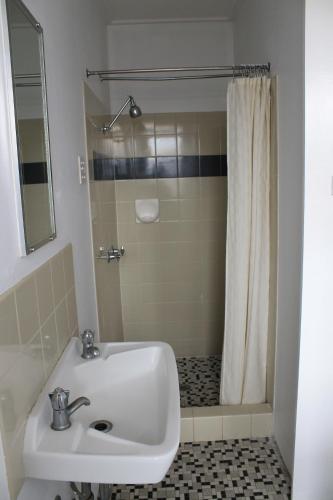 a bathroom with a sink and a shower at Hotel Beach House Nambour in Nambour