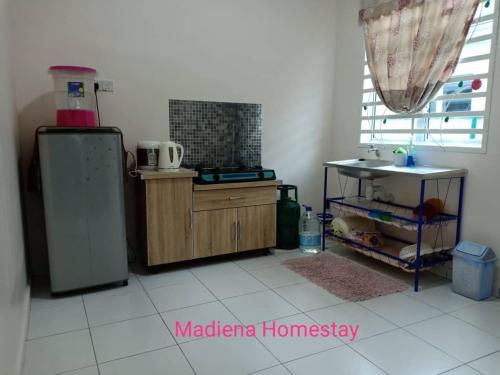 uma cozinha com um frigorífico e um lavatório em Madiena Homestay em Kampung Gurun