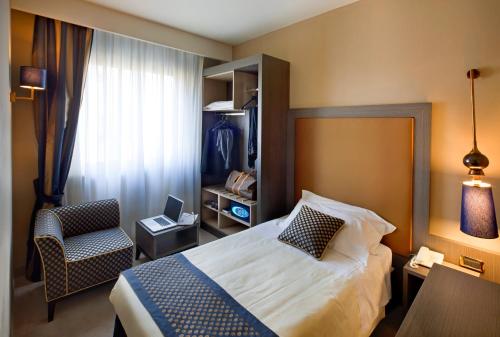 a hotel room with a bed and a chair at Hotel Mozart in Milan