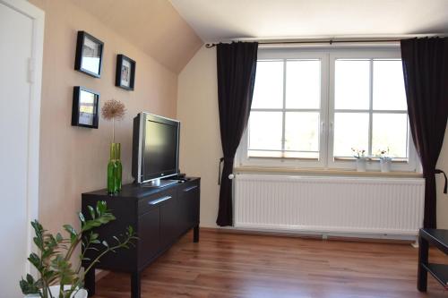 a living room with a television and a window at Ferienwohnung-Sonnenblume in Grube