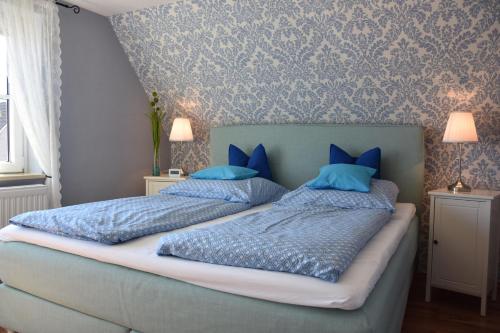 - une chambre avec 2 lits dotés d'oreillers bleus dans l'établissement Ferienwohnung-Sonnenblume, à Grube