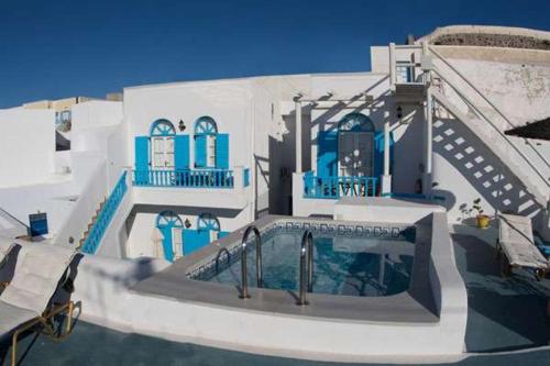 a building with a swimming pool in front of it at Vallas Apartments & Villas in Firostefani