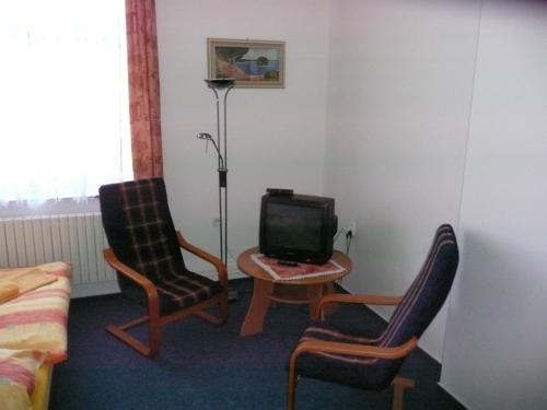a room with two chairs and a table with a tv at Koleje Zamecek in Lednice