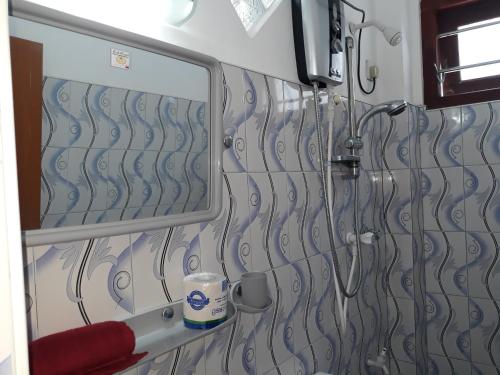 una ducha en un baño con espejo en Copacabana Beach Hotel, en Hikkaduwa