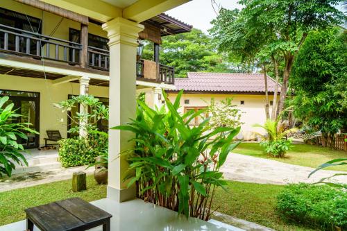 a house with a bench in front of it at Mr Tho's Bungalows in Don Det