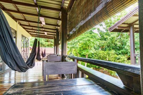 a porch with a hammock and a table and chair at Mr Tho's Bungalows in Don Det