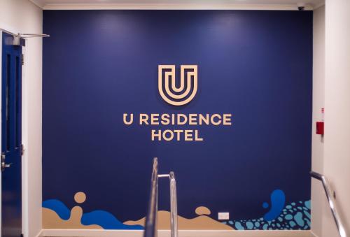 a blue wall with the uresurance hotel sign at U Residence Hotel in Wellington