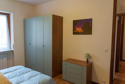 a bedroom with a bed and a dresser and a cabinet at Luminoso bilocale in Alessandria