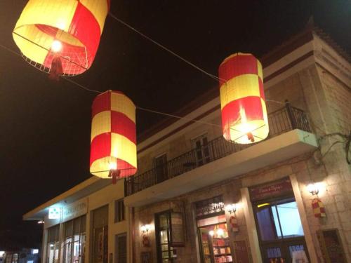 two red and yellow lanterns hanging in front of a building at Rodomelo House with Terrace - 4 Bedrooms in Leonidion