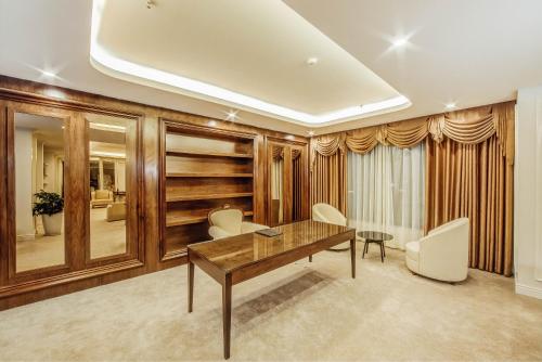 a dining room with a wooden table and white chairs at Muong Thanh Luxury Bac Ninh Hotel in Bắc Ninh