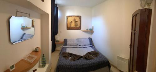 a small room with a bed and a mirror at Ker Viviane in Dinan