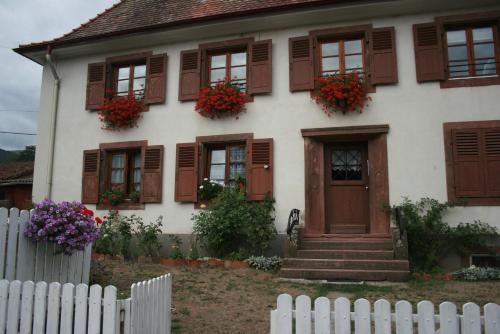 una casa blanca con flores en las ventanas en Maison d'Alsace, en Breitenbach-Haut-Rhin