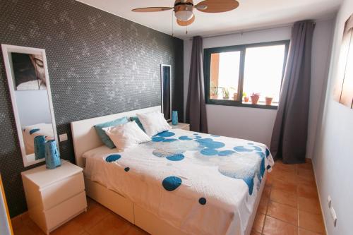 Paraiso 1 SG في بلايا بارايسو: غرفة نوم مع سرير مع الزهور الزرقاء عليه