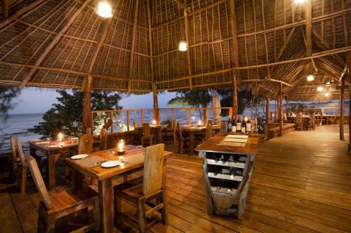 a restaurant on the beach with tables and chairs at The Island - Pongwe Lodge in Pongwe