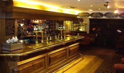 a bar in a restaurant with a counter at Stags Head Hotel in Bowness-on-Windermere