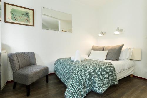 ein Schlafzimmer mit einem Bett und einem Stuhl in der Unterkunft Chamois Blanc Terrasse in Chamonix-Mont-Blanc