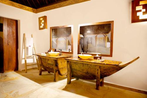 a bathroom with two wooden sinks in a room at The Island - Pongwe Lodge in Pongwe