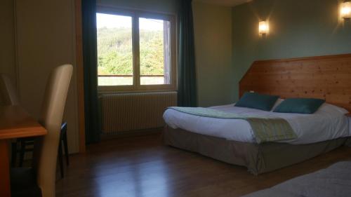 a bedroom with a bed and a window at Logis Le Saint Cyr in Montmelard