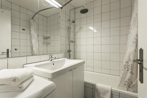 a white bathroom with a sink and a tub at Apartment Lyret in Chamonix