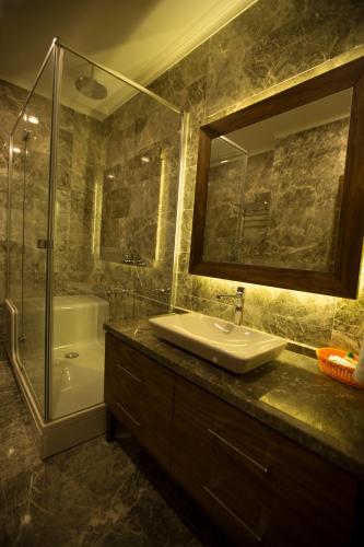 a bathroom with a sink and a shower and a mirror at Ermenek Selcuklu Otel in Ermenek