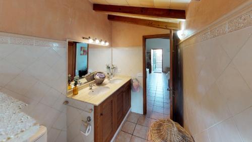 a bathroom with a sink and a mirror and a shower at Can Toniet in Sóller