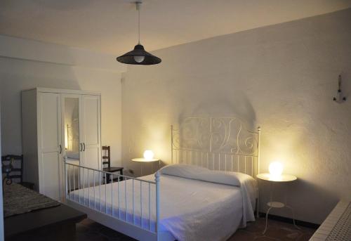a bedroom with a bed with two tables and two lamps at Casa Capiciana - punta rotolo in Milazzo
