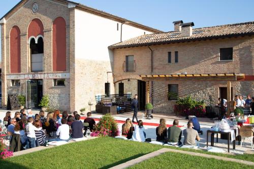 a group of people sitting in front of a building at Agriturismo La Ratta in Vernasca