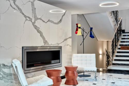 a living room with a fireplace and a tv at Antigon Urban Chic Hotel, Thessaloniki in Thessaloniki