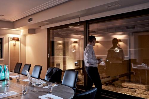 a man standing in front of a window in a restaurant at Antigon Urban Chic Hotel, Thessaloniki in Thessaloniki