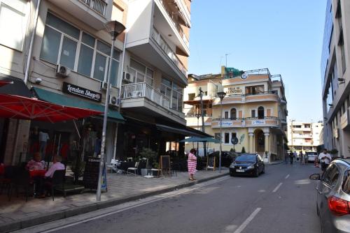 una calle de la ciudad con edificios y una persona de pie en la acera en Alindro City Center Apartment 2 en Tirana