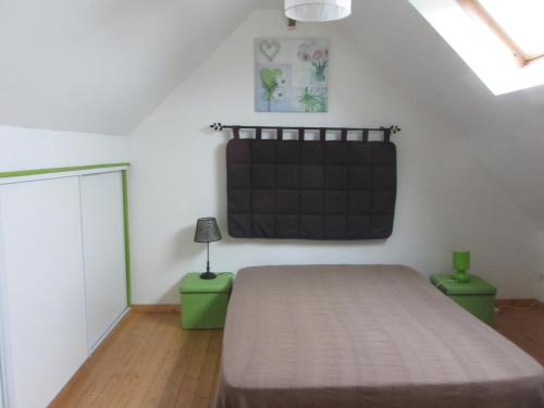 1 dormitorio con 1 cama y una pizarra en la pared en Le Bosvillais, en Bosville