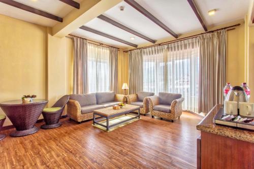 a living room with a couch and chairs and a tv at Da Yatra Courtyard Hotel in Pokhara