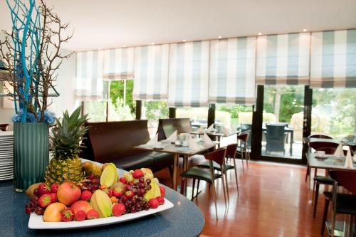 a plate of fruit on a table in a restaurant at Atrium im Park Hotel Regensburg in Regensburg