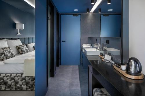 a hotel room with a bed and two sinks and a bathroom at Urban Creme in Prague