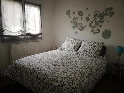 1 Schlafzimmer mit einem Bett mit einer Bettdecke und 2 Fenstern in der Unterkunft la Maison de Lilly in Pierry