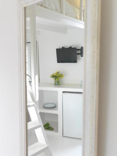 a staircase leading up to a loft bed with a tv at ALSAKI SUITE by K&K in Oia