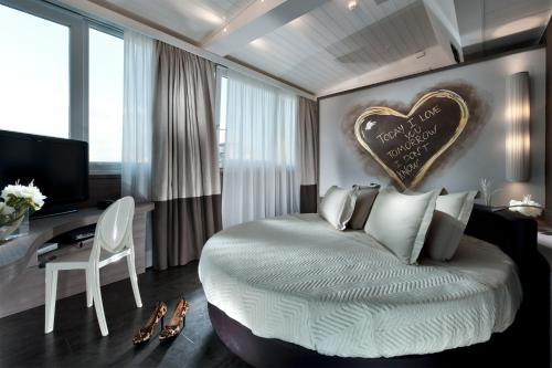 a bedroom with a large bed with a heart on the wall at Hotel Lungomare in Cesenatico