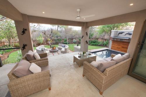 a living room with couches and a swimming pool at Nyaleti Lodge in Hoedspruit